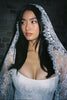 Woman with Mantilla Lace Veil paired with lace wedding dress