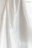 A close-up of draped white fabric with soft folds