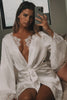 Woman taking a mirror selfie in a satin bridal robe