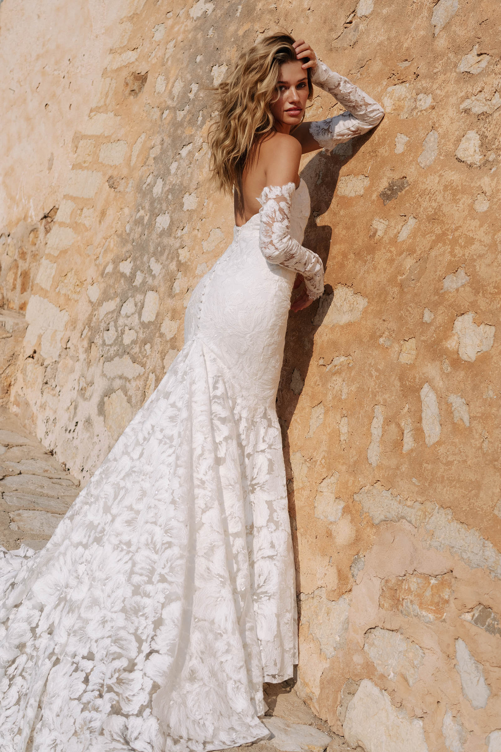 Woman in a lace wedding dress against a textured wall_XS_
