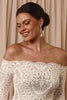 Woman wearing a lace off-shoulder gown and pearl drop earrings