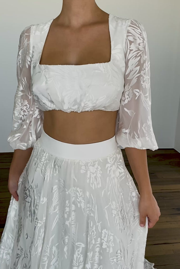 A woman wearing a two-piece wedding dress.