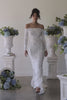 A woman in a lace off the shoulder wedding dress.